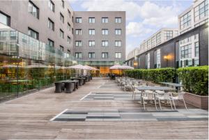 un patio con mesas, sillas y edificios en Holiday Inn Express Beijing Airport Zone, an IHG Hotel, en Beijing