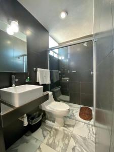 a bathroom with a toilet and a sink and a shower at Hotel Maria Sofia ViaCapu in San Felipe Hueyotlipan