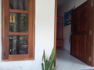 eine offene Tür zu einem Zimmer mit Fenster in der Unterkunft Myro Cottage in Weligama + 3 Fotos