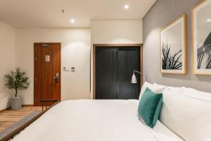 A bed or beds in a room at The Glomad Boutique Danang