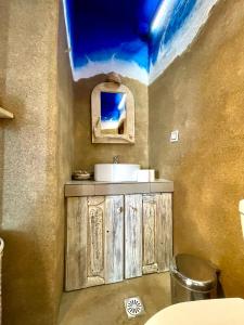 a bathroom with a sink and a counter with a mirror at Villa Zografos in Iraklia