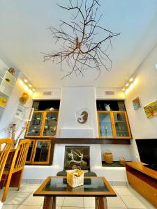 a living room with a tree branch hanging from the ceiling at Villa Zografos in Iraklia