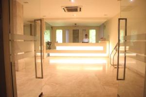 a person standing in a hallway with a person in a mirror at J Hotel in Port Blair +28 photos