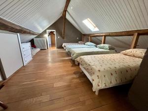 fila de camas en una habitación con suelo de madera en Le domaine de Jade, en Châtillon-la-Borde