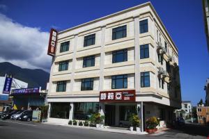 un gran edificio blanco con un cartel delante en Silia Hostel, en Jian