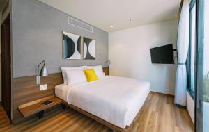A bed or beds in a room at The Glomad Boutique Danang