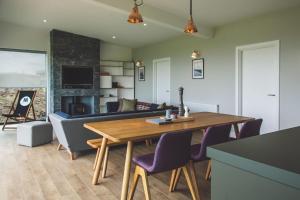 a living room with a wooden table and purple chairs at Jog Lodge 20 - 3 Bed Sea-View in Wick