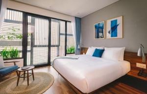 A bed or beds in a room at The Glomad Boutique Danang