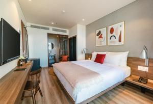 A bed or beds in a room at The Glomad Boutique Danang