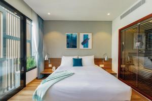 A bed or beds in a room at The Glomad Boutique Danang