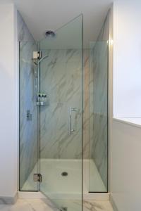 a shower with a glass door in a bathroom at Indulge in Christchurch Hagley Park 2 bed 2 bath in Christchurch