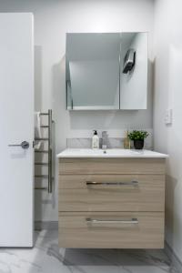 a kitchen with a sink and a refrigerator at Indulge in Christchurch Hagley Park 2 bed 2 bath in Christchurch