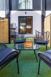 a group of chairs and a table on a patio at Indulge in Christchurch Hagley Park 2 bed 2 bath in Christchurch