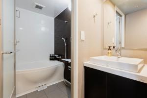 a bathroom with a sink and a bath tub and a shower at Hotel Wing International Shizuoka in Shizuoka
