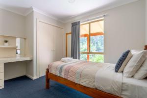 a white bedroom with a bed and a window at Mansfield Retreat - In Town - Margaret River in Margaret River Town