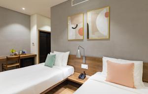 A bed or beds in a room at The Glomad Boutique Danang