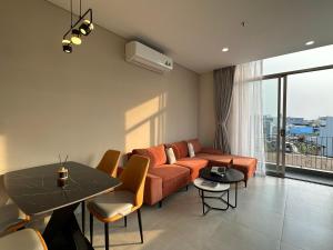 a living room with a couch and a table at Khe Suites Serviced Apartment - Han River in Danang