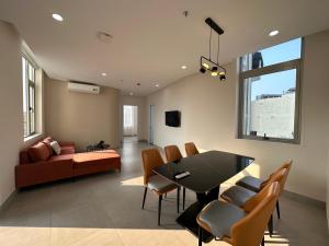 a dining room and living room with a table and chairs at Khe Suites Serviced Apartment - Han River in Danang