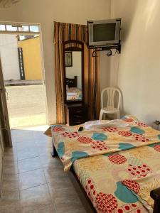 ein Schlafzimmer mit einem Bett und einem TV an der Wand in der Unterkunft Hospedaje DJ in Buga