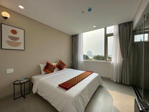 a bedroom with a white bed and a large window at Khe Suites Serviced Apartment - Han River in Danang +38 photos