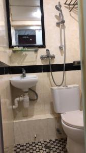 a bathroom with a sink and a toilet and a mirror at 富都賓館 Fu Dou Guest House in Hong Kong