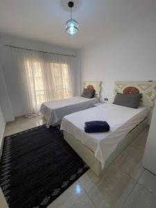 - une chambre avec 2 lits et un tapis dans l'établissement مدينتى, à Madinaty
