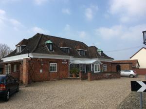 ein Haus mit einem davor geparkt in der Unterkunft Swan Motel in Beccles