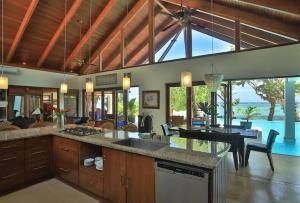 a kitchen and living room with a view of the ocean at The Jewel of The Coral Coast in Tangangge