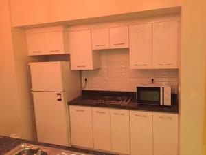 Lovely 3-bedroom vacation home -Marassi في الإسكندرية: مطبخ أبيض مع ثلاجة وميكروويف