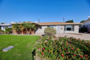 a house with a yard with flowers in front of it at Amazing Location! Old Town Scottsdale Modern Home in Scottsdale