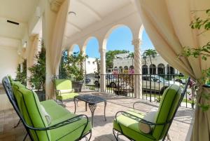 een veranda met groene stoelen en een tafel bij Studio in the heart of Palm Beach, free valet parking included in Palm Beach