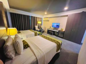 a hotel room with two beds and a television at 88 Courtyard Hotel in Manila