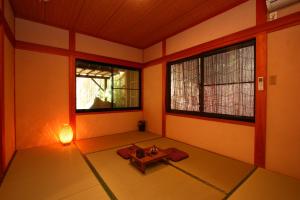 an empty room with a table and two windows at YamakawaZENZO in Oguni