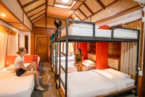 three women sitting on bunk beds in a room at Mad Monkey Pai in Pai