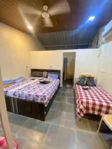 a room with two beds and a ceiling at Green Fog Guesthouse in Lonavala
