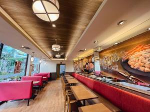 a restaurant with red chairs and a counter with a buffet at 88 Courtyard Hotel in Manila