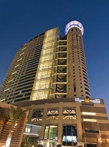 a tall building with a dome on top of it at Grand Millennium Al Wahda Executive Apartments in Abu Dhabi