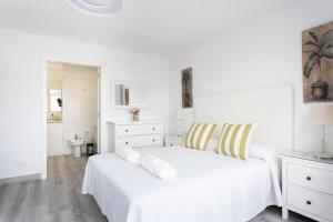 een slaapkamer met een wit bed en witte kasten bij 106 Medano Perfect Seaviews By Sunkeyrents in El Médano
