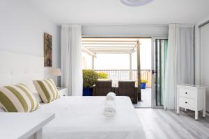 a white bedroom with a bed and a living room at 106 Medano Perfect Seaviews By Sunkeyrents in El Médano