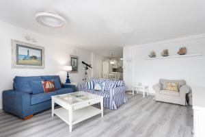 een woonkamer met een blauwe bank en een tafel bij 106 Medano Perfect Seaviews By Sunkeyrents in El Médano