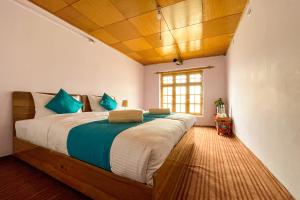 a bedroom with a large bed with blue pillows at Astrostays at Pangong Lake in Spangmik
