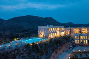 a building with a swimming pool at night at Tree of Life Vantara Resort & Spa in Udaipur
