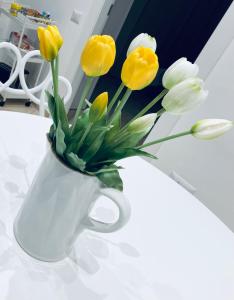 un vaso bianco con fiori gialli e bianchi di Tutta un'altra vista a Salerno