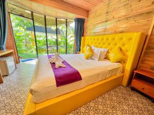 um quarto com uma cama grande e uma cabeceira amarela em Moly Resort em Kampot