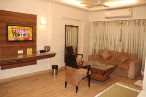 salon z kanapą i stołem w obiekcie Kyriad Hotel Indore by OTHPL w mieście Indore