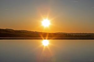 a sun setting over a body of water at Domaine de Rambeau in Castelmoron-sur-Lot