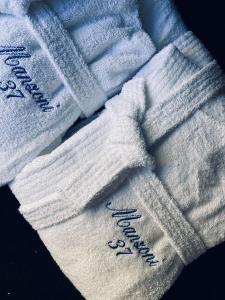 two white knitted towels with writing on them at LOFT MANZONI 37 in Cremona