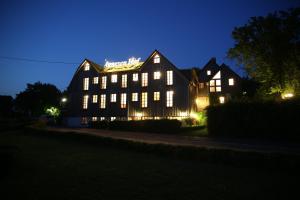 un gran edificio iluminado por la noche en Hotel Agnesen-Hof en Barweiler