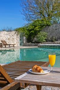 uma mesa com um prato de pão e um copo de sumo de laranja em Domaine de Rambeau em Castelmoron-sur-Lot