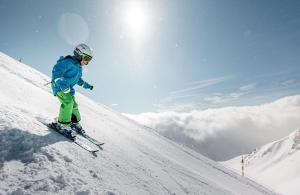 a person is skiing down a snow covered slope at Taubenhaus OG in Fiesch